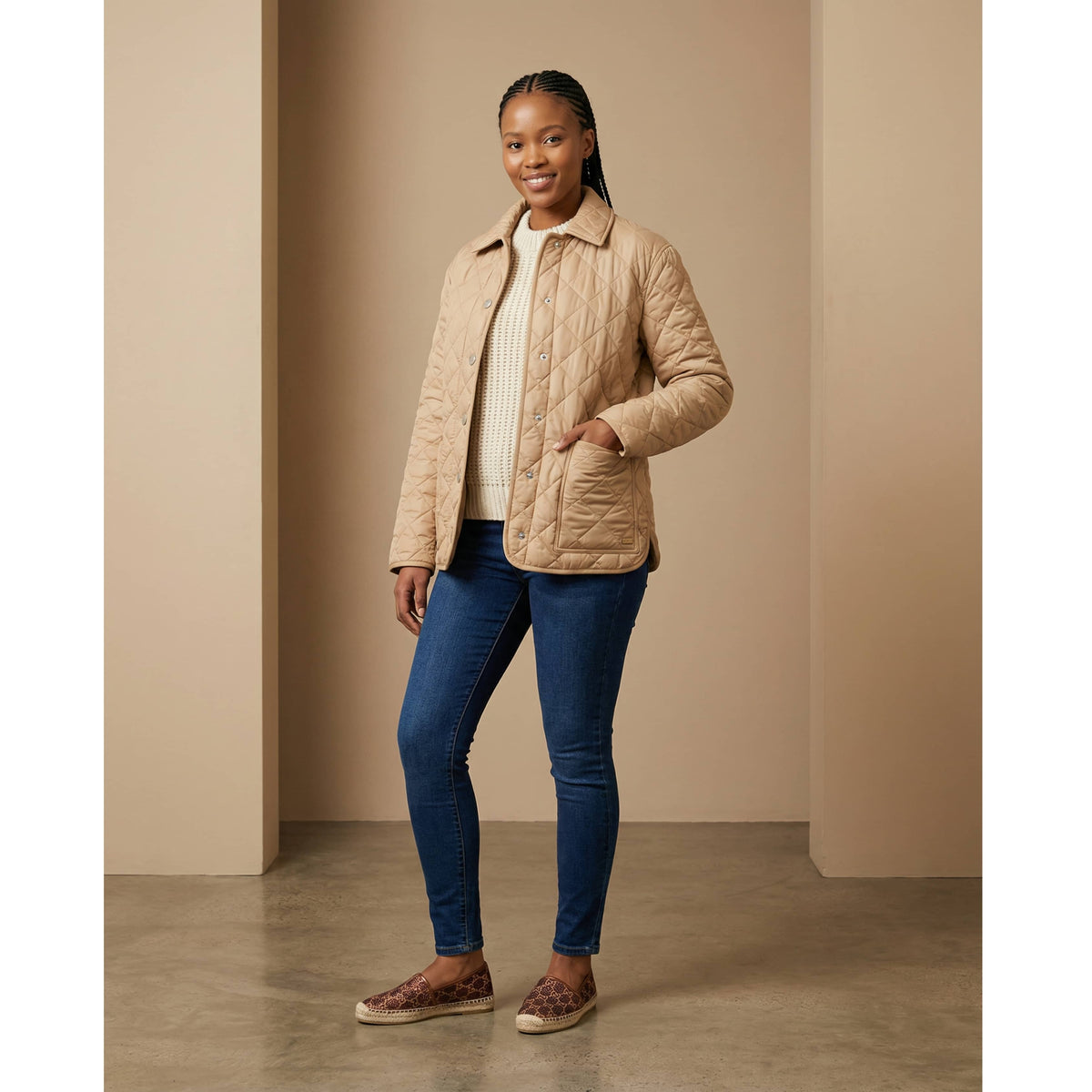 Full-length studio view of a model wearing the Burberry Dalry camel quilted jacket styled with a casual outfit.