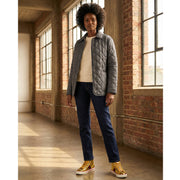 Full-length studio view of a model wearing the black Burberry Dalry quilted jacket styled with blue jeans and sneakers