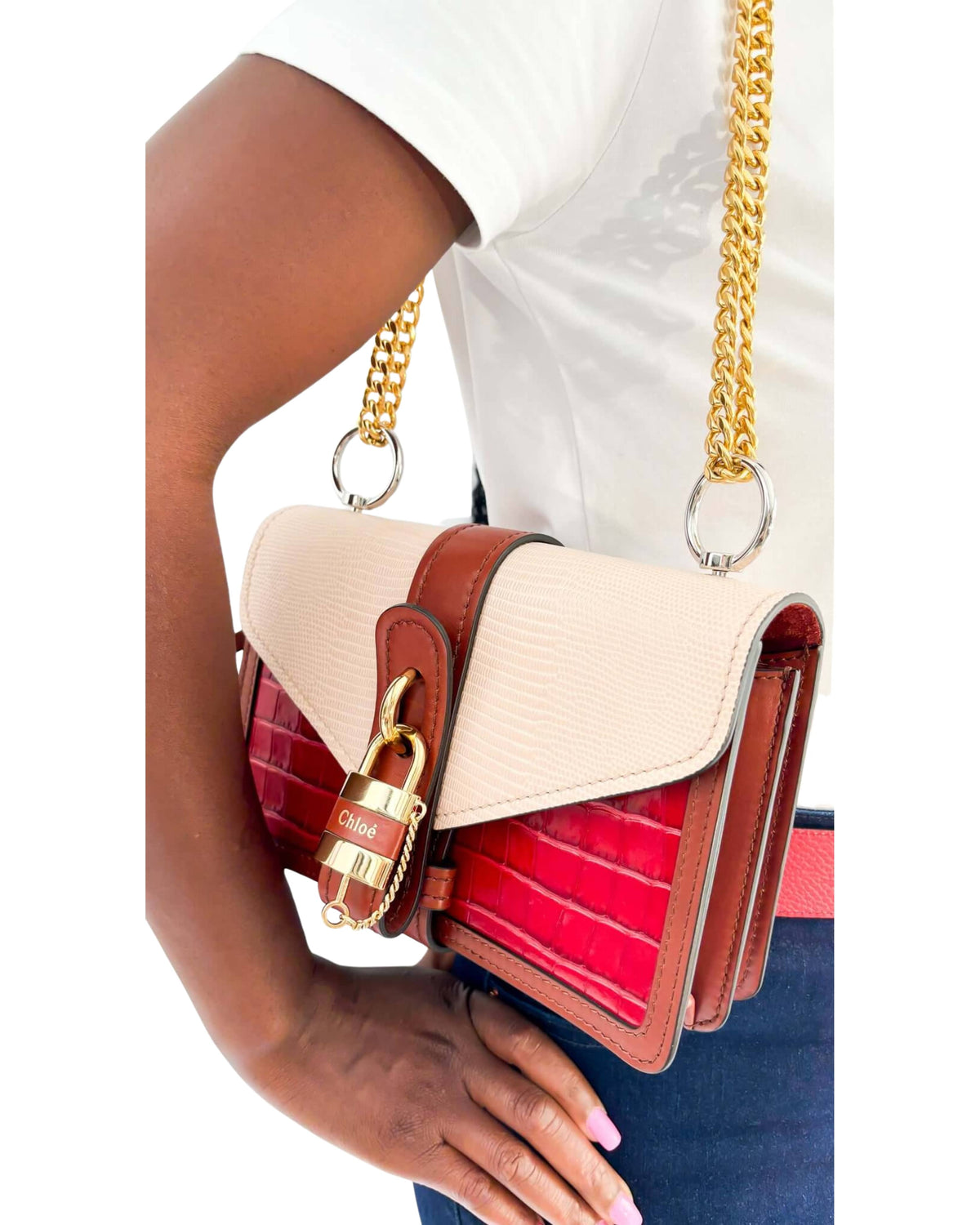On-body side view of a model carrying the multi-color Chloé Aby Day Chain bag by its elegant gold-tone chain strap.