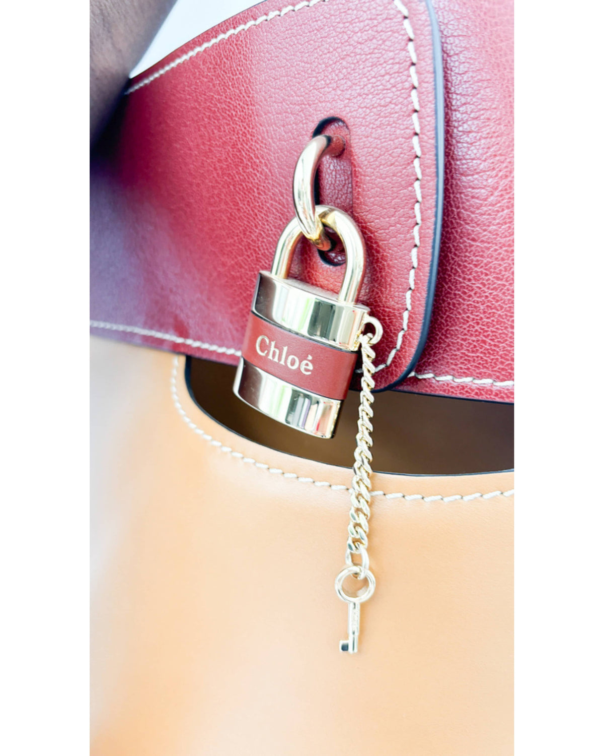 Close-up of Chloé Aby Day bucket bag in autumnal brown showing lock and leather detail