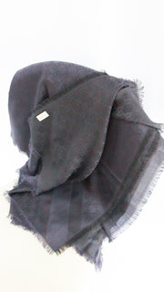 Folded view of navy Gucci GG monogram scarf displaying jacquard woven silk wool fabric texture.