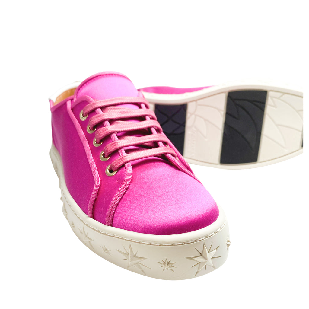 Front angle of Aquazzura LA low-top pink satin sneakers, highlighting the star-embossed white platform sole and patterned rubber outsole tread