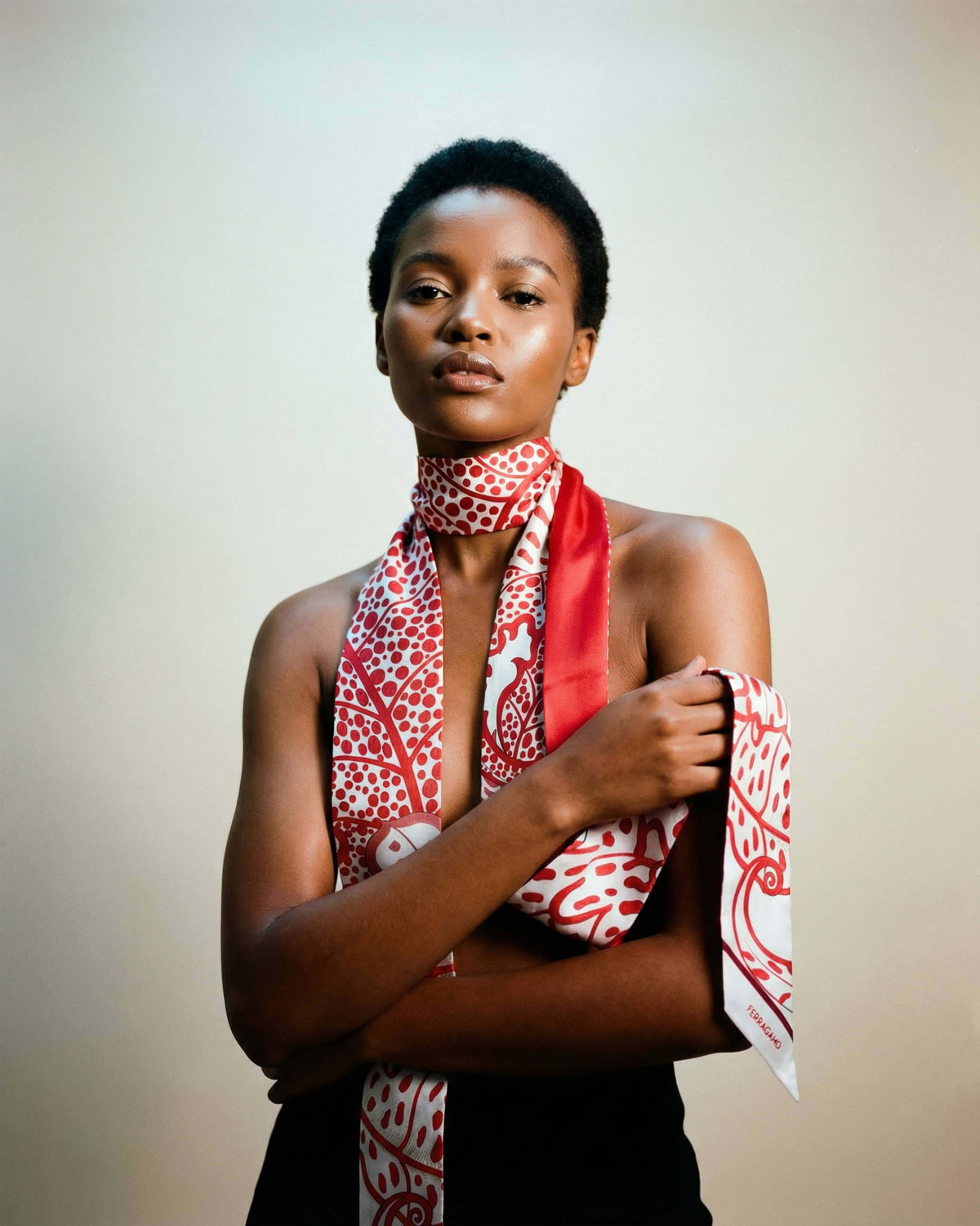Model wearing the Salvatore Ferragamo red botanical foliage silk scarf tied gracefully around her neck.