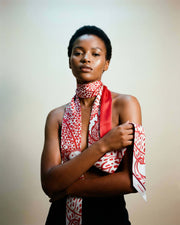 Model wearing the Salvatore Ferragamo red botanical foliage silk scarf tied gracefully around her neck.