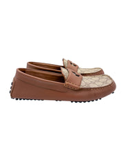 Side profile view of Gucci driver loafer displaying Clove brown leather trim and GG Supreme pattern.