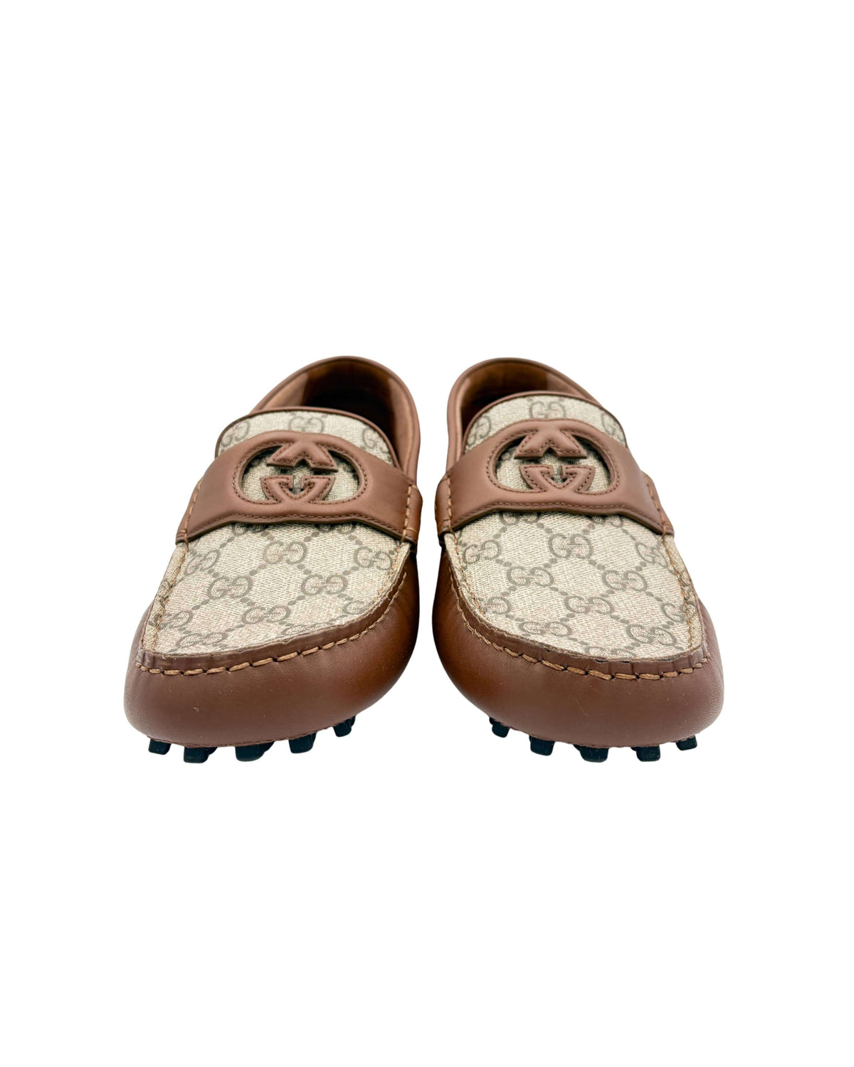 Front view of a pair of Gucci GG Supreme canvas driver moccasins with interlocking GG embellishments.