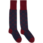 Pair of Gucci navy blue and red intarsia knit long socks displayed side-by-side showcasing the contrast cuff and toe construction.