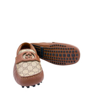 Angled profile view of Gucci GG Supreme driver moccasin showing rubber pebble tread sole.