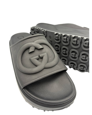 Close-up of embossed GG detail on Gucci black rubber slide