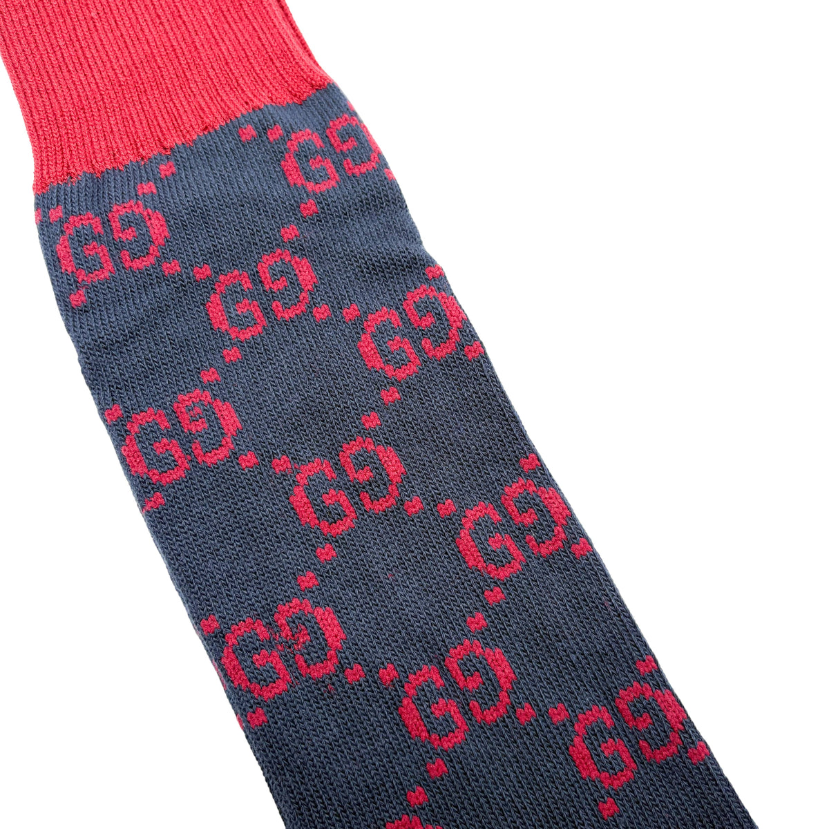 Detailed close-up view of the red GG monogram pattern on the navy blue Gucci stretch cotton intarsia knit sock.