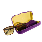 Gucci brown tortoise rectangular sunglasses presented alongside luxury purple velvet hard case and satin flannel pouch
