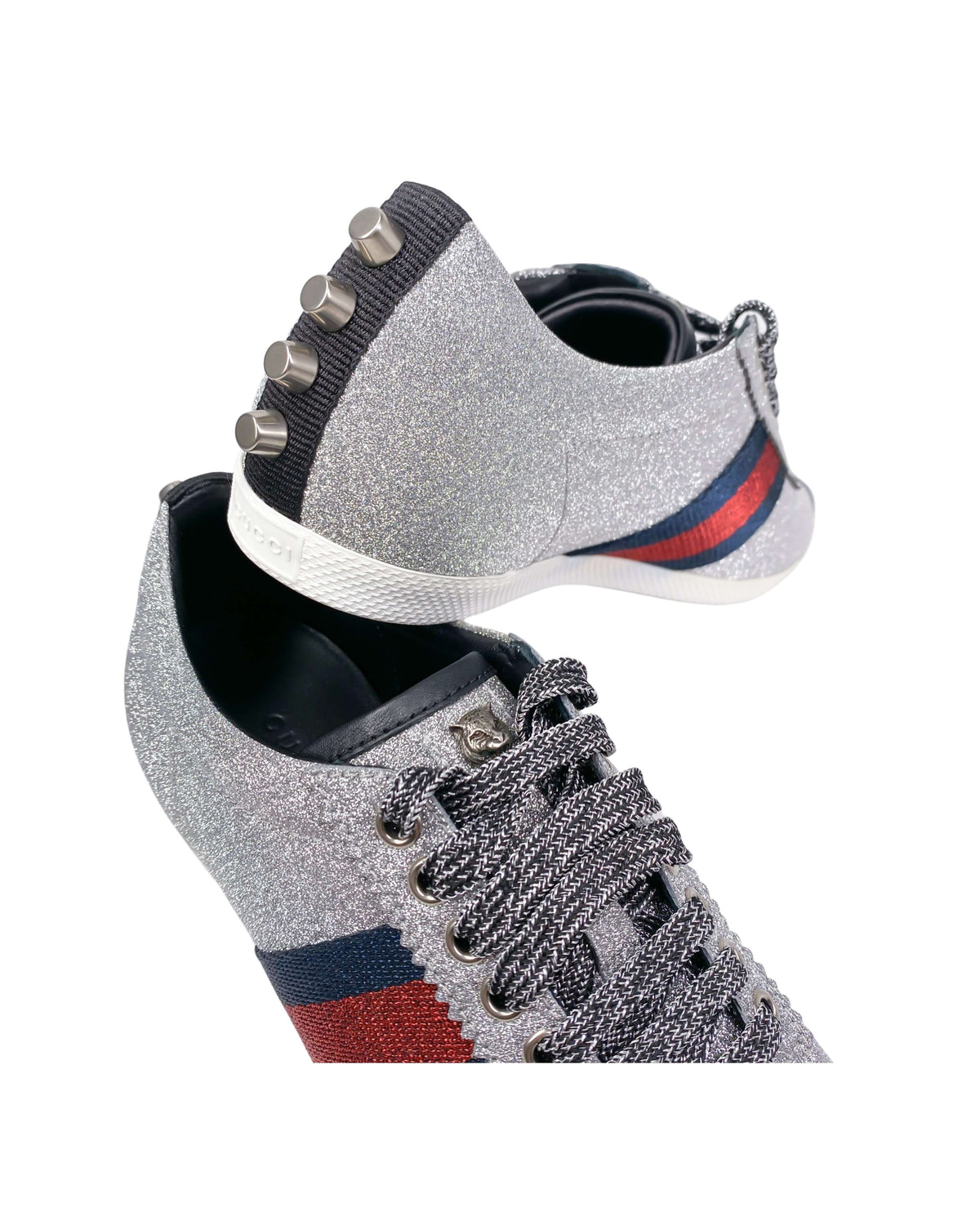 Close-up detail of Gucci silver trainers showing logo and metallic finish