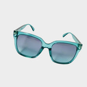 Front view of Gucci sunglasses featuring a bold turquoise translucent frame and gradient lenses.
