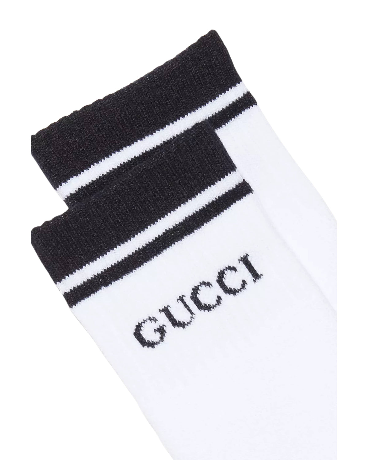 Close-up angled view of white Gucci logo striped tennis socks showing ribbed cuff texture and designer logo detail