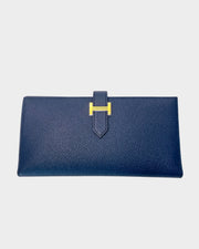 Hermès Bearn Soufflet wallet in Blue Indigo leather featuring the signature silver-tone metal H tab leather clasp closure.