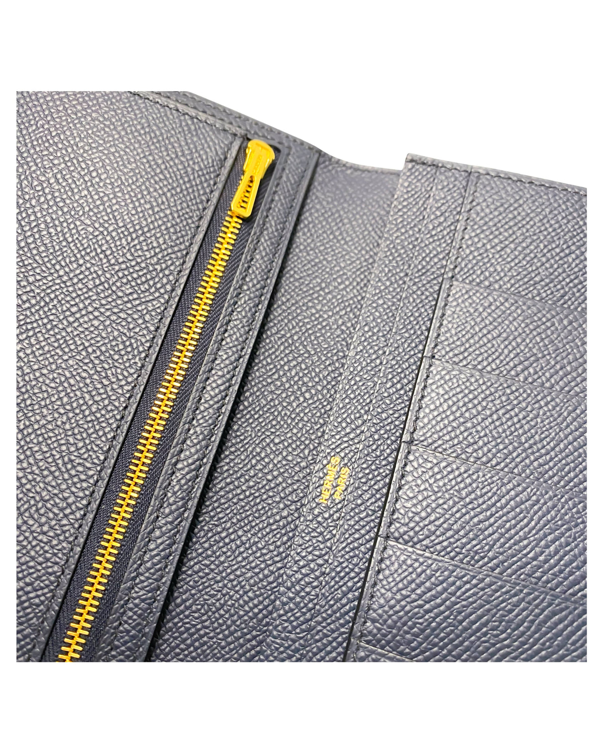 Close-up detail view of the interior zip pocket and metallic zipper pull inside the Hermès Bearn Soufflet wallet in Blue Indigo.