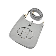 Angled top view of Hermès Evelyne Amazone 16 in Gris Patin highlighting the perforated H emblem, soft leather grain, and shoulder strap ring attachment.