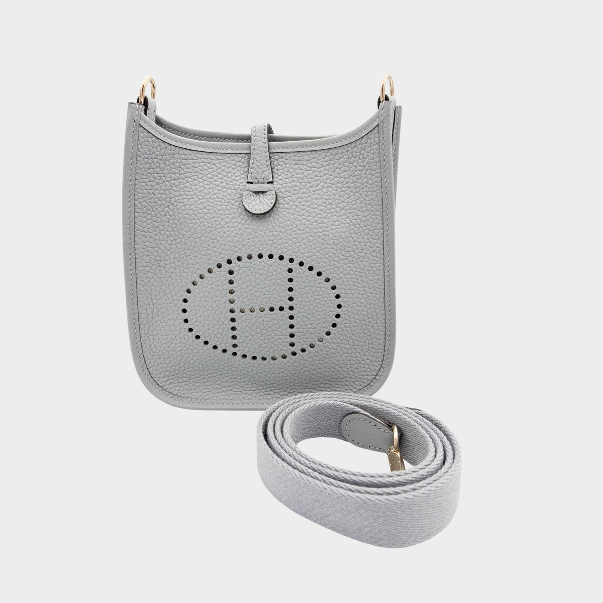 Hermès Evelyne Amazone 16 crossbody bag in Gris Patin grey Clemence leather showcasing signature perforated H logo and detachable canvas strap.