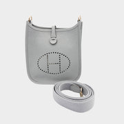 Hermès Evelyne Amazone 16 crossbody bag in Gris Patin grey Clemence leather showcasing signature perforated H logo and detachable canvas strap.
