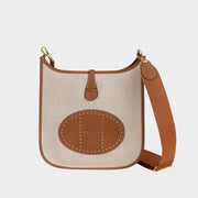Front view of Hermès Evelyne III 29 handbag crafted in Écru H canvas and Gold Taurillon Clemence leather trim, featuring the signature perforated H logo.