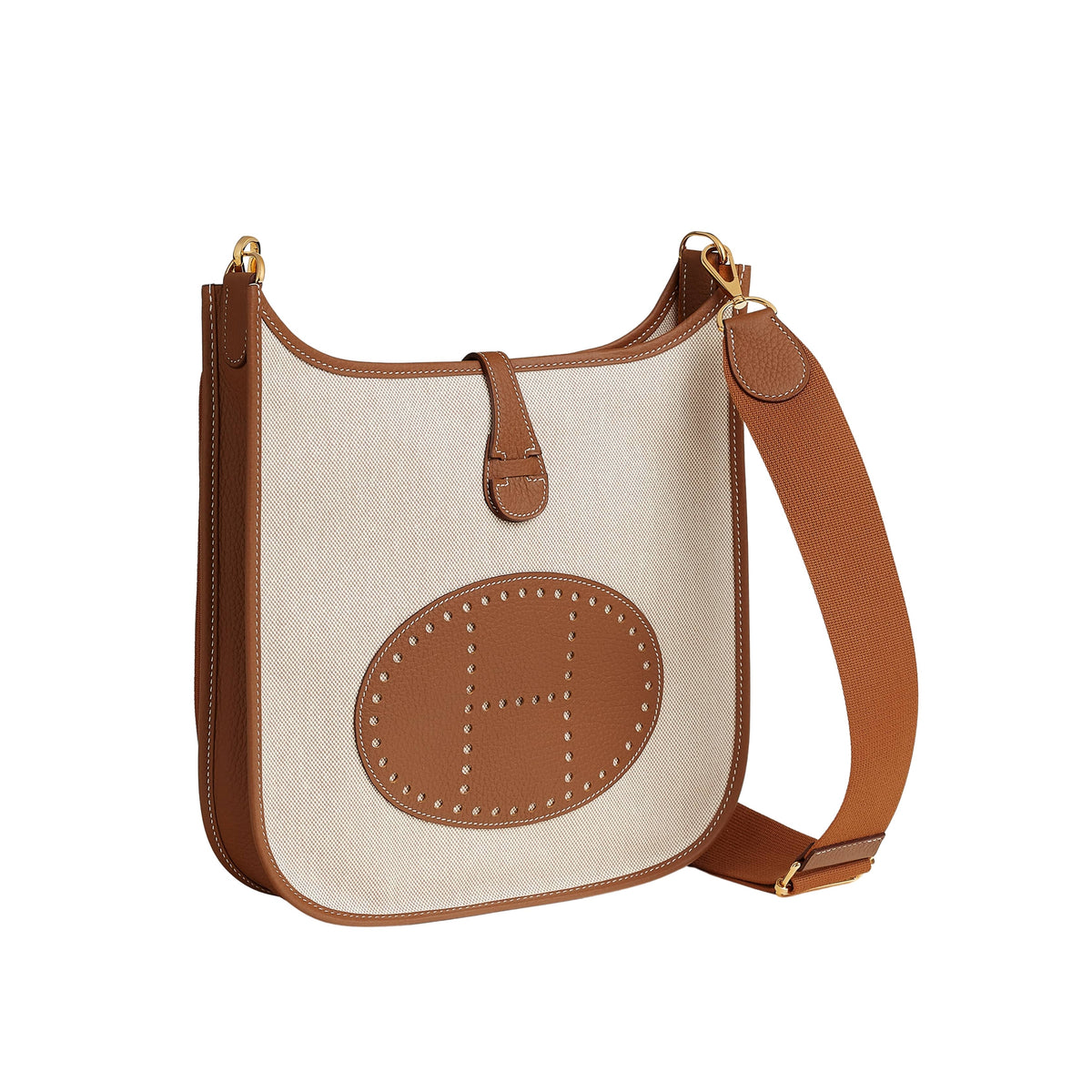 Direct front view of the Hermès Evelyne III 29 bag in Écru canvas and Gold leather detailing the oval perforated H emblem and structured body.