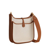 Rear view of Hermès Evelyne III 29 bag in Écru canvas showing the functional exterior slip pocket and Gold leather trim.