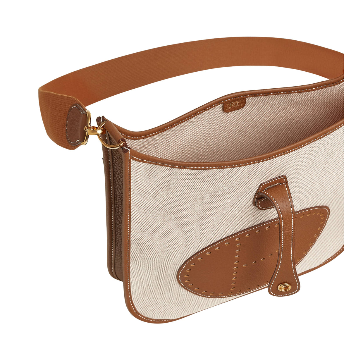 Top angled view of Hermès Evelyne III 29 bag in Écru and Gold leather displaying the snap closure leather tab and open top compartment.