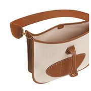 Top angled view of Hermès Evelyne III 29 bag in Écru and Gold leather displaying the snap closure leather tab and open top compartment.
