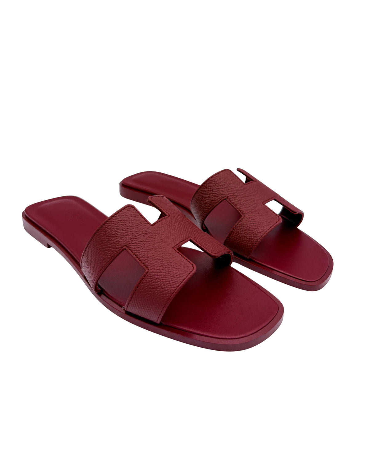 Overhead top-down perspective of Hermès Oran Framboise leather sandals showcasing the footbed and H strap contour.