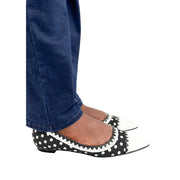 Side view of a person wearing Manolo Blahnik Elaphiria polka dot slip-on flats styled with dark denim jeans.