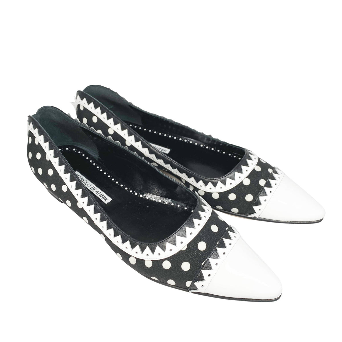 Top-down studio shot of the Manolo Blahnik Elaphiria polka dot flats showcasing the premium textile upper and round throat line.