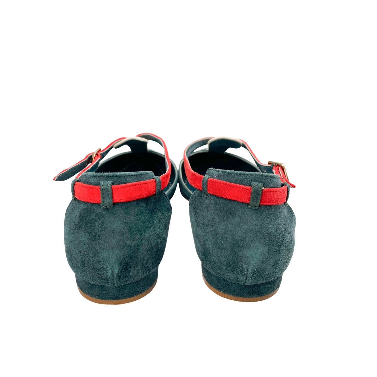 Rear view of a pair of Manolo Blahnik Vree green suede flats detailing the pink heel straps and flat heel profile.