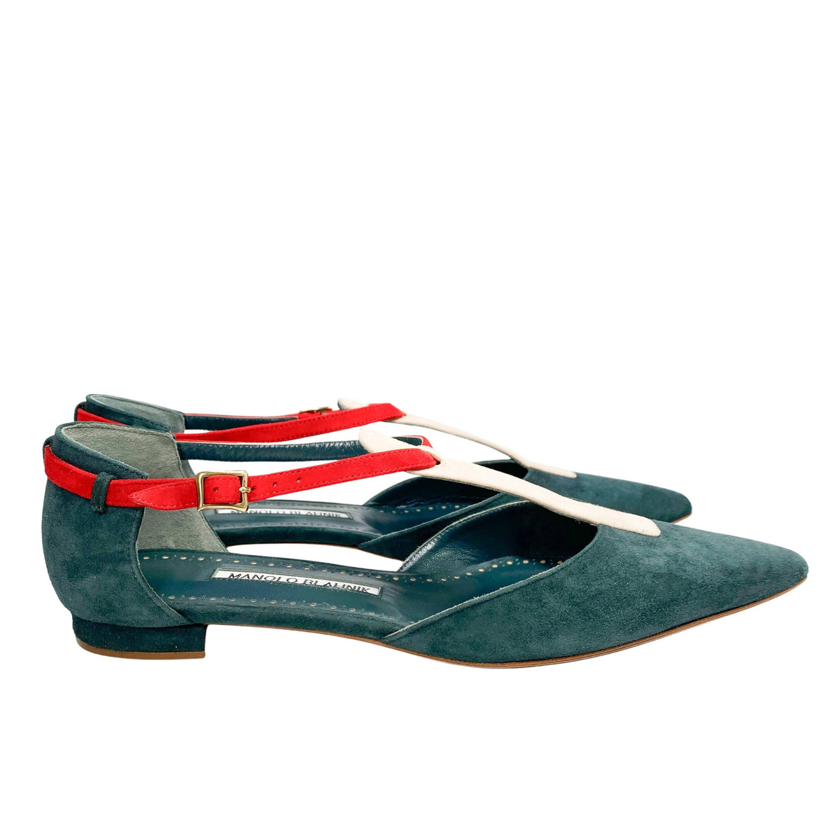 Side profile view of Manolo Blahnik Vree green suede flat shoe showing the sleek silhouette and pink strap construction.
