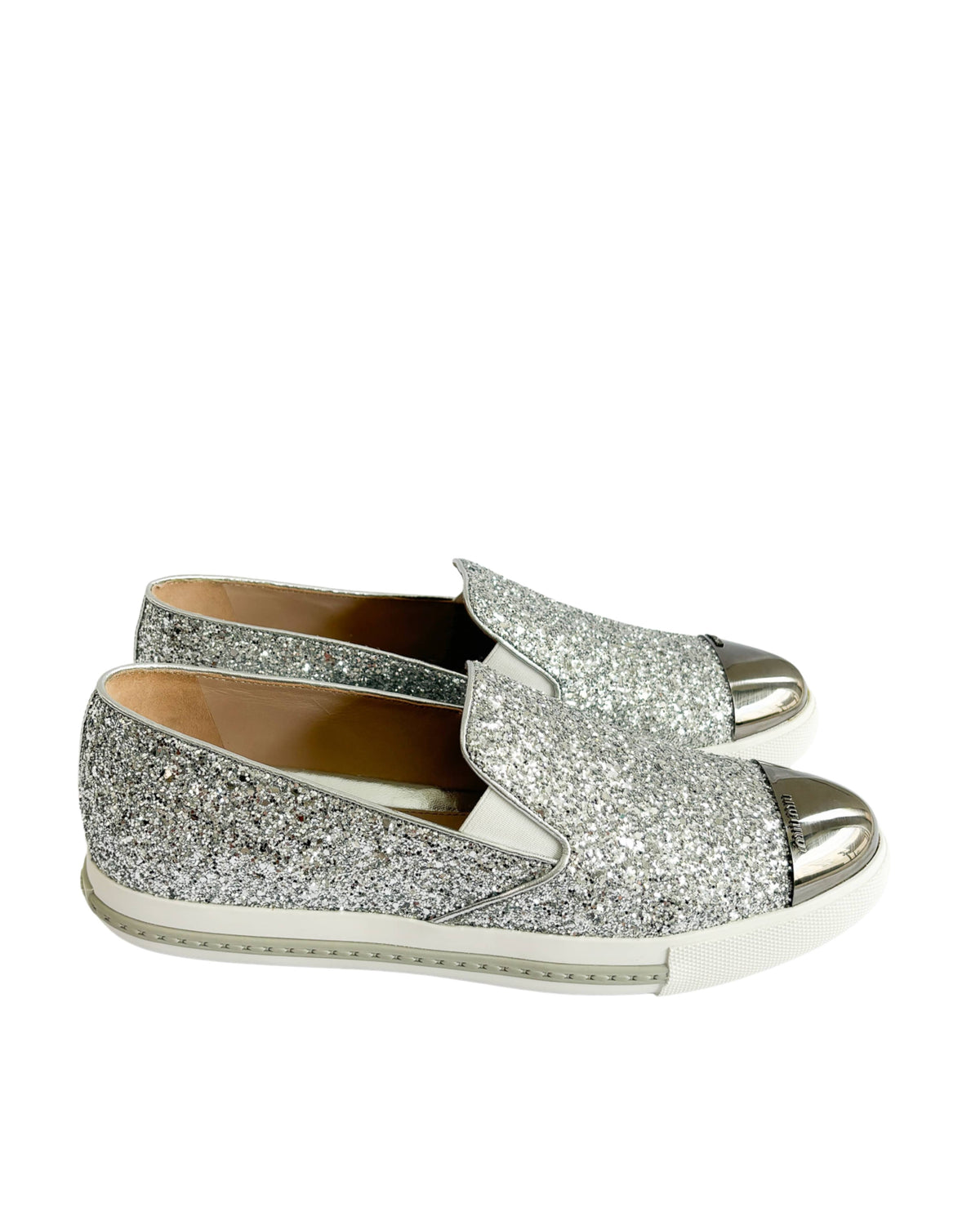Side view of Miu Miu round toe slip-on sneakers with silver glitter finish