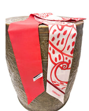 Angled side view of the red Ferragamo foliage print silk scarf draped over a display stand.