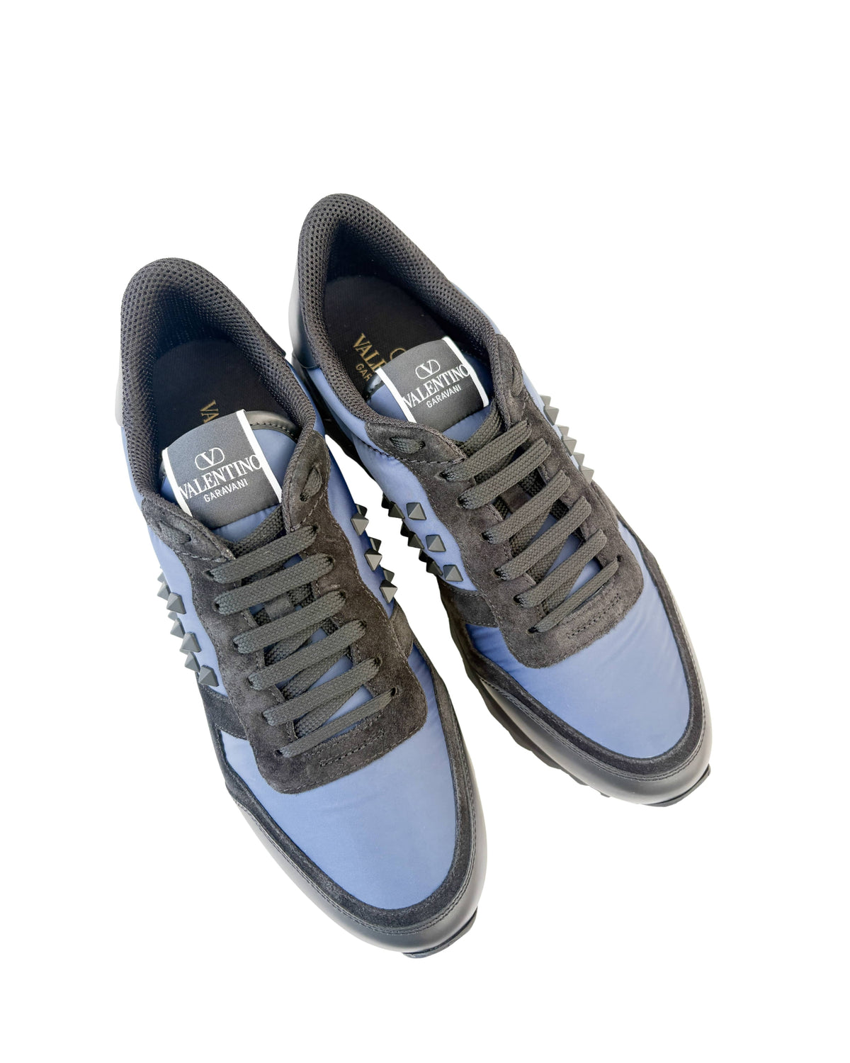 Top-down angled view of a pair of Valentino Rockrunner navy sneakers showing branded insoles and black laces.