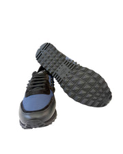 Angled profile view of Valentino Rockrunner trainer showcasing black rubber outsole and navy suede upper.