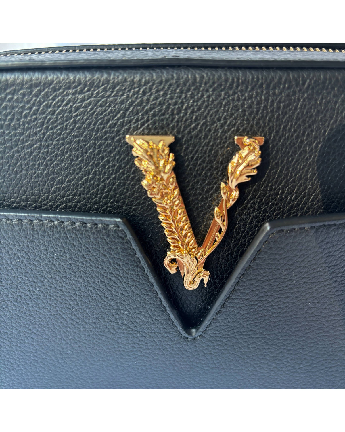 Close-up of Versace Virtus camera bag showing signature V emblem
